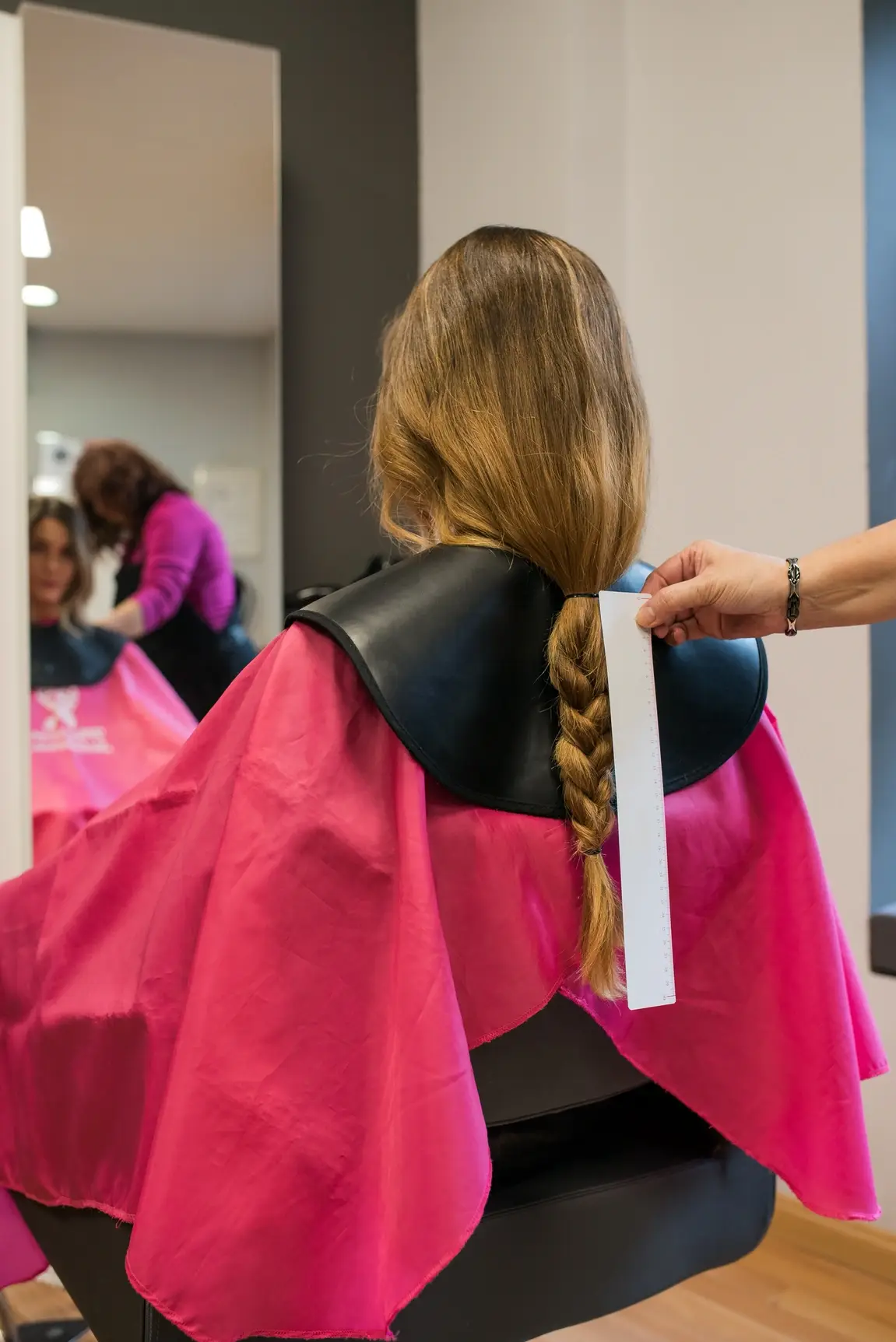 Woman's hair getting measured before it's cut.