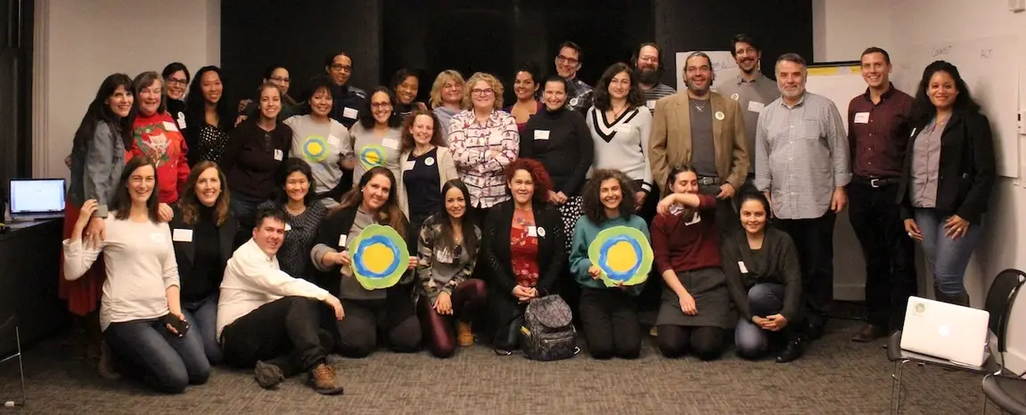 A group of idealists smile for a photo.