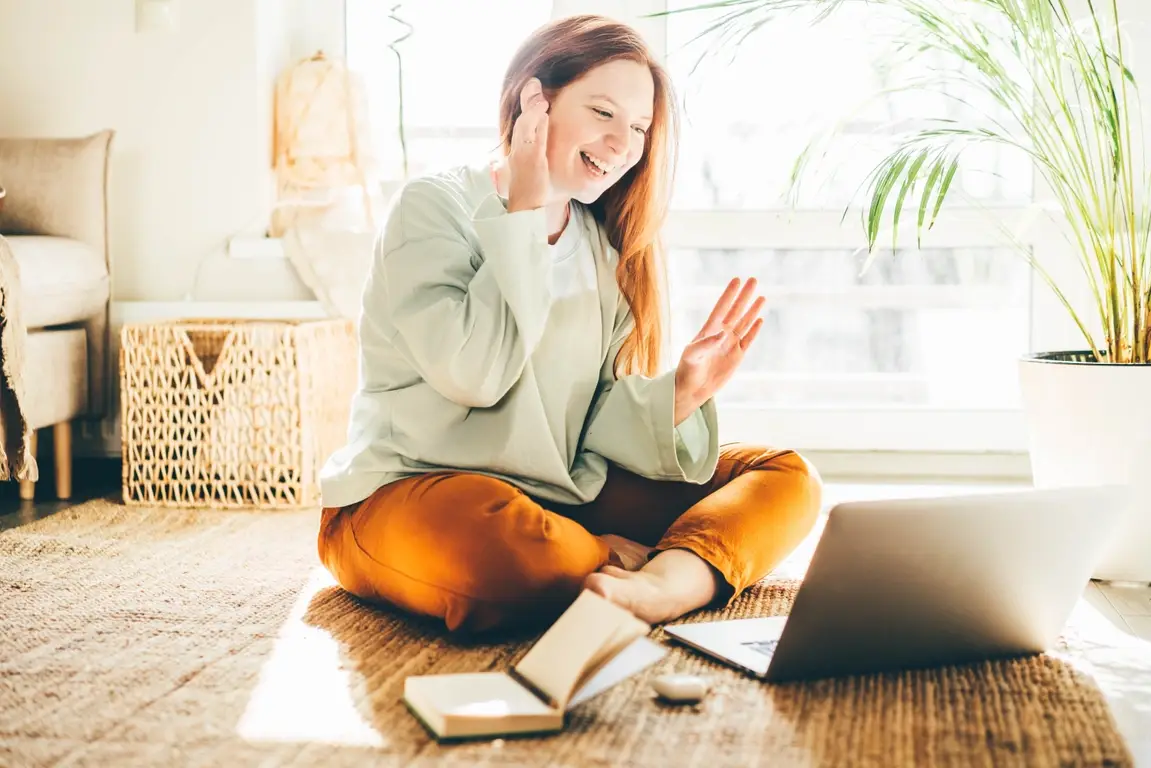 Woman smiling at home during a virtual meeting | What is Ableism? Confronting Ableism in the Workplace