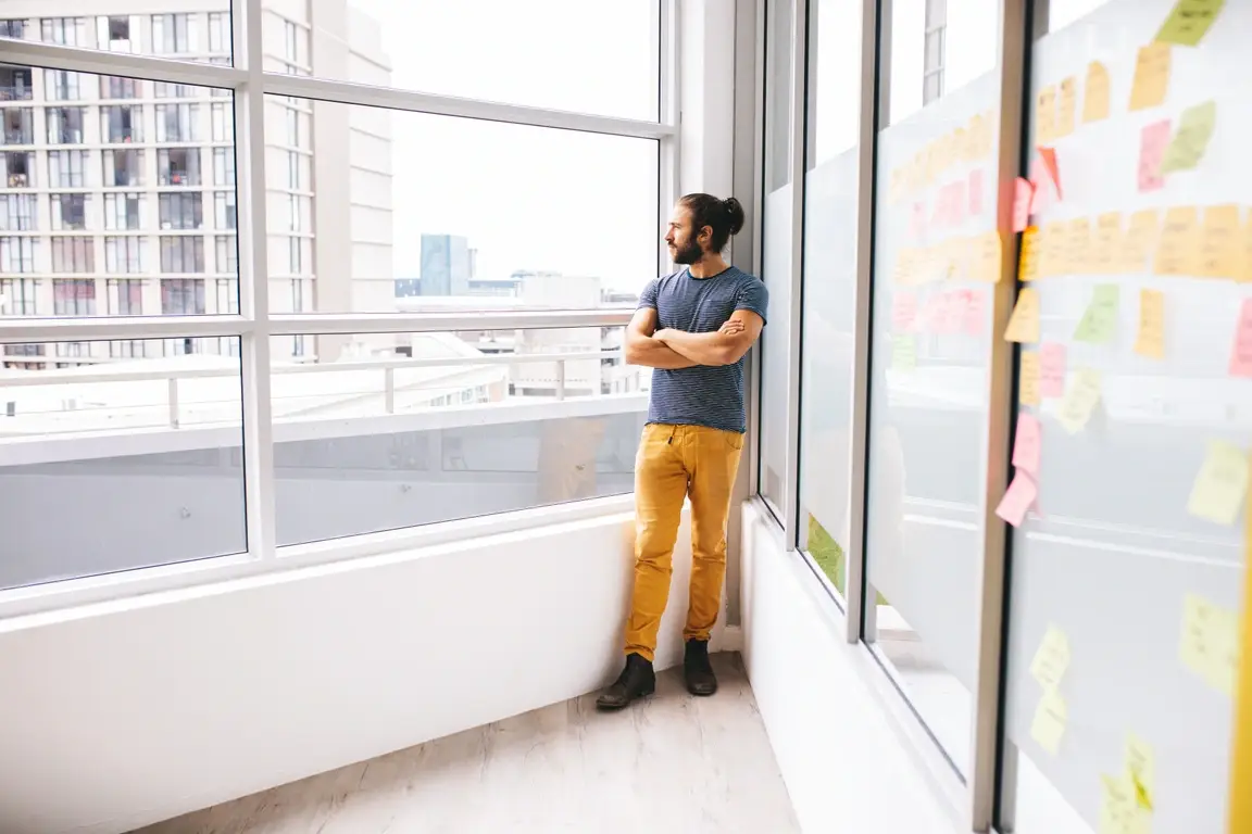 Someone standing and looking out a window.