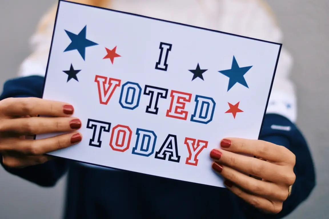 Woman holding a sign that says "I Voted Today."