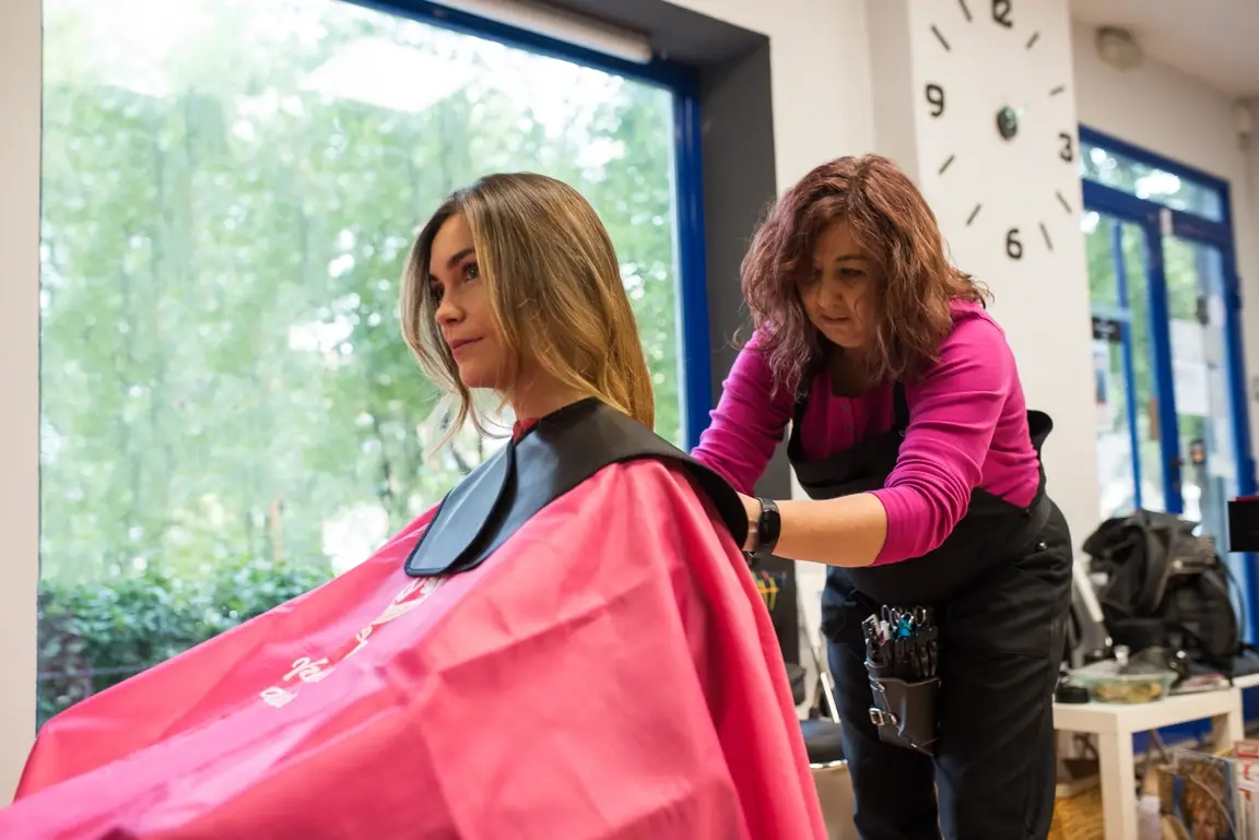 Woman getting ready to cut another woman's hair.