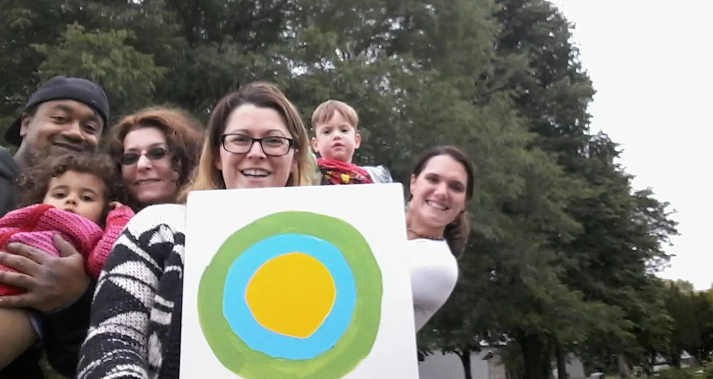 Friends holding a painted Idealist logo.