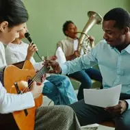 Organizer at music and arts organization teaches students how to play instruments