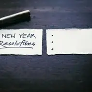 Pedacinho de papel com o escrito "New Year Resolutions" (resolução de ano novo) e três pontinhos