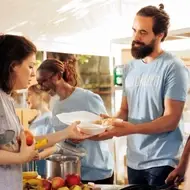 Personas voluntarias entregan comida a quien lo necesita.