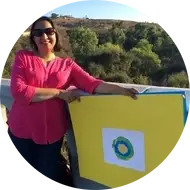 A woman holds up the Idealist logo.