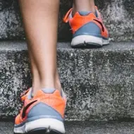 A  shot of a person's sneakers. They are climbing steps.