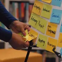 Hands in front of a board with sticky notes