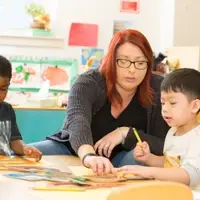 Teacher with two young students in learning center