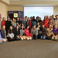 Staff members from the Karen Organization of Minnesota pose for a group photo in two rows.