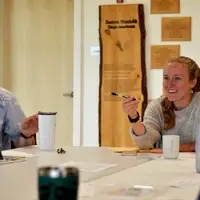 Two people sit at a table engaged in conversation