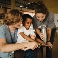 Volunteers reading with a student in the auditorium