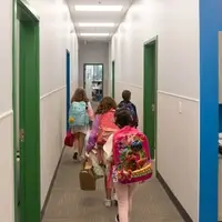 Students walk down the hall with their backpacks.