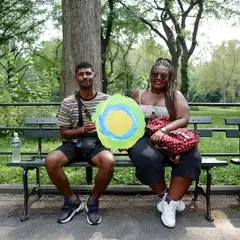 Two people pose with the Idealist logo between them.