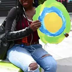 Uma mulher está sentada e segurando o símbolo idealista