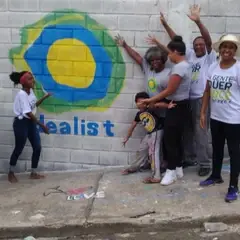 Turma de pessoas mostra o símbolo do idealist pintado na parede