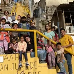 Children and volunteers in group on the stairs near the classroom