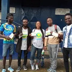 A group of people pose with cards that say Idealist on it.