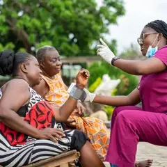 A healthcare professional carrying out immunisation in a village