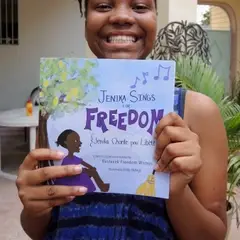 a young author poses with her book