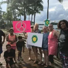 Um grupo de pessoas segurando o logo da Idealista e outras artes de manifestação.