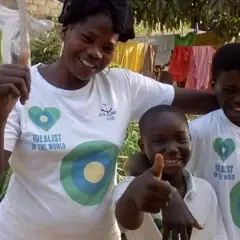 A group of people with their thumbs up pose with Idealist shirts on