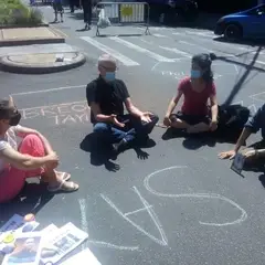 Volunteers sitting around the phrase, "Say her name."