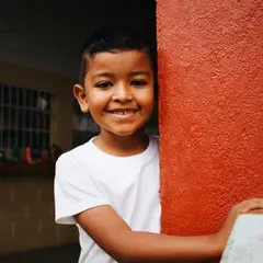 Student hugging the wall and smiling