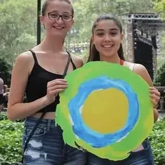 Duas mulheres no parque Union Square posam com o logotipo da Idealist entre elas.