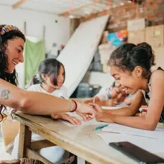 A volunteer is teaching a child