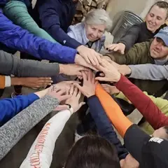 Mill Town Rowing athletes are huddled up and hands-in, motivating each other after practice.