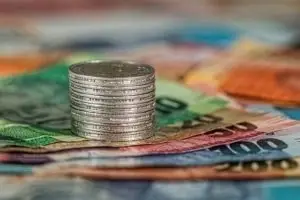 Una columna de monedas sobre unos billetes