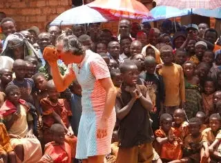 A clown entertaining a group of kids.