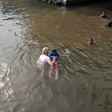 Volunteer teaches the kids how to swim