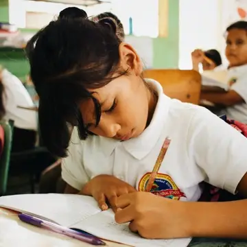 San Jeronimo student writing at her desk