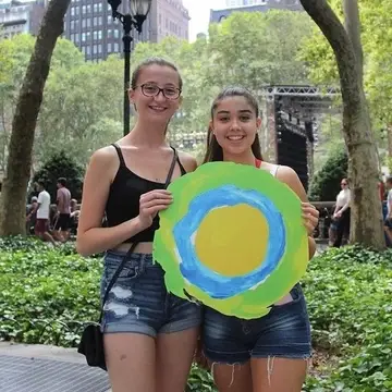 Two people pose with the Idealist logo between them.