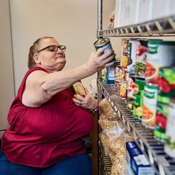 Woman stocking canned foods on shelves