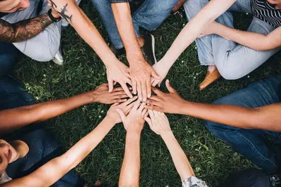 Mãos juntos em torno de um círculo simbolizando a união.