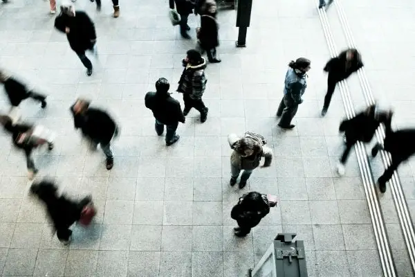 Muchas personas caminando en una acera