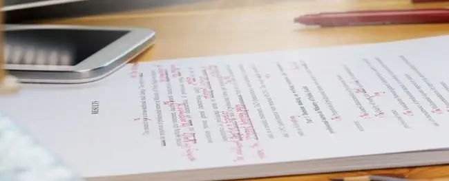 image of paper being marked up by red pen