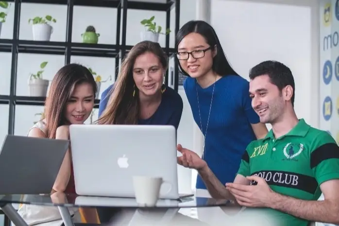 Equipo de jóvenes trabajadores con una voluntaria ofreciendo probono