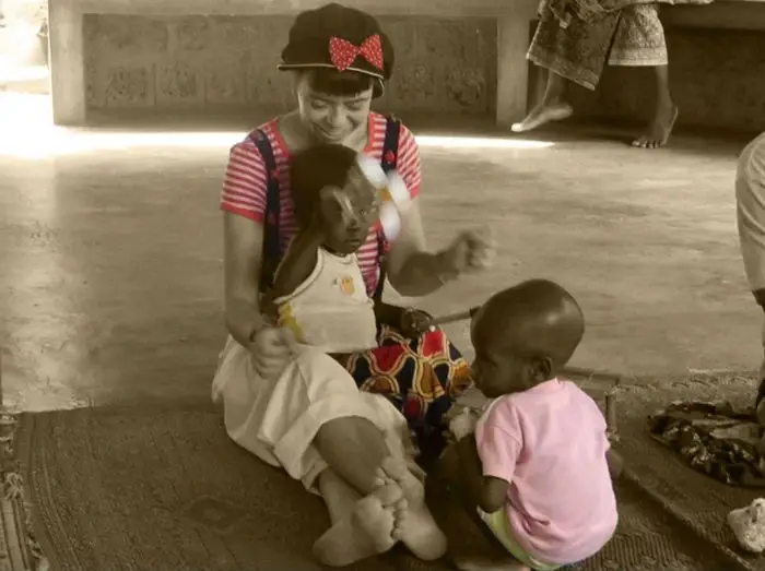 A lady playing with two babies