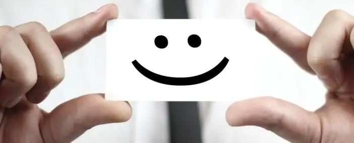 Someone holding a business card with a smiley face on it.