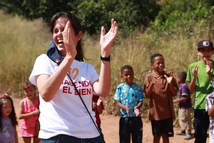 Mujer aplaudiendo con niños al fondo