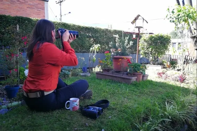 Mujer tomando foto en un jardín