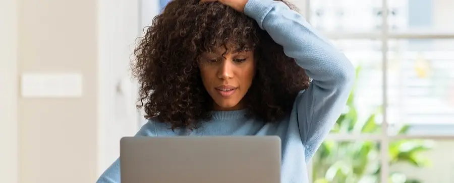 A woman looking at a laptop.