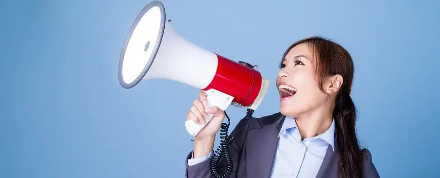 A woman talking into a megaphone.