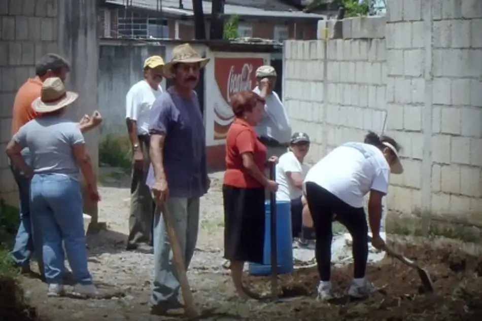 Membros da comunidade trabalhando juntos em um pedaço de terra