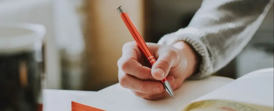 Close up in a hand writing in a notebook.